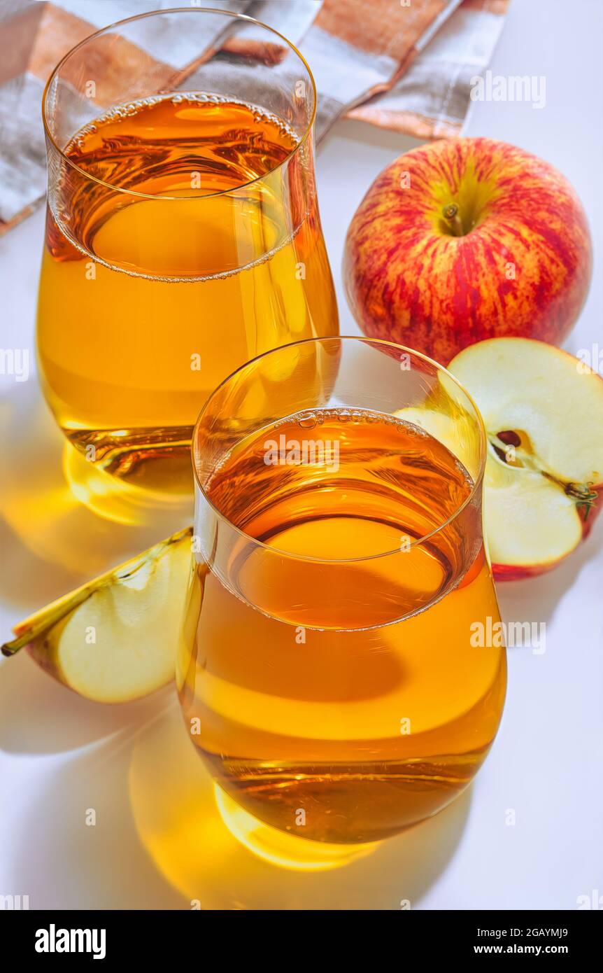 Ein Glas Apfelsaft und frischer Apfel auf weißem Hintergrund. Stockfoto