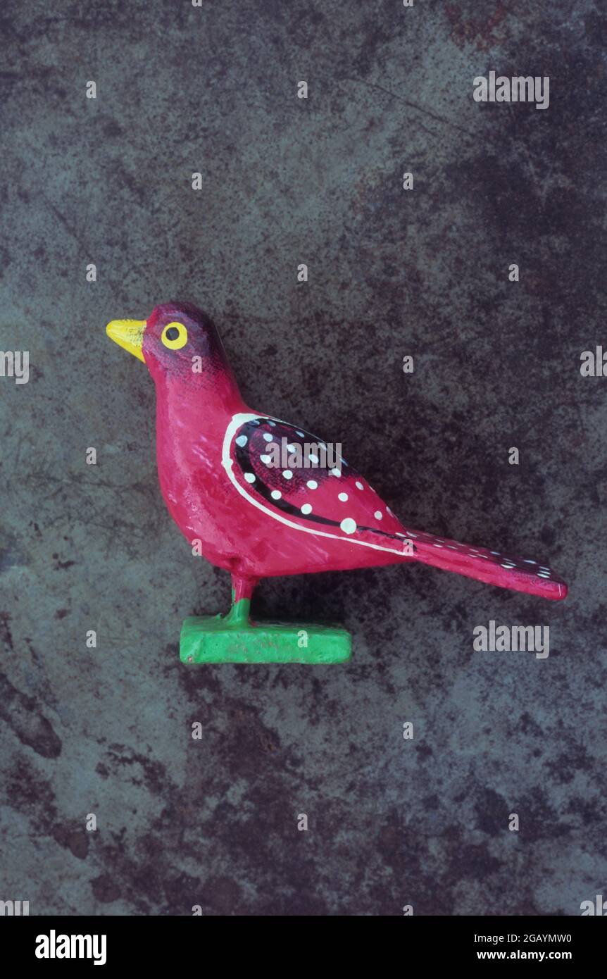 Naive Holzmodell des Vogels rot mit weißen Flecken gemalt Stockfoto