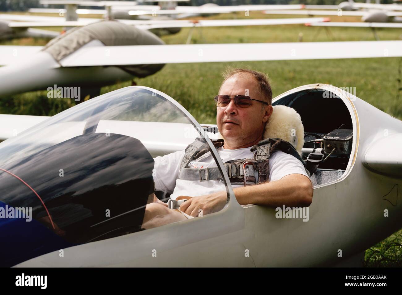 Reifer Segelflugpilot im Flugzeug vor dem Flug. Blick auf die Steuertafel oder Flugzeuge auf dem Land. Fixed-Wing-Flugzeug ohne Motor. Rasant sportlicher Sport Stockfoto