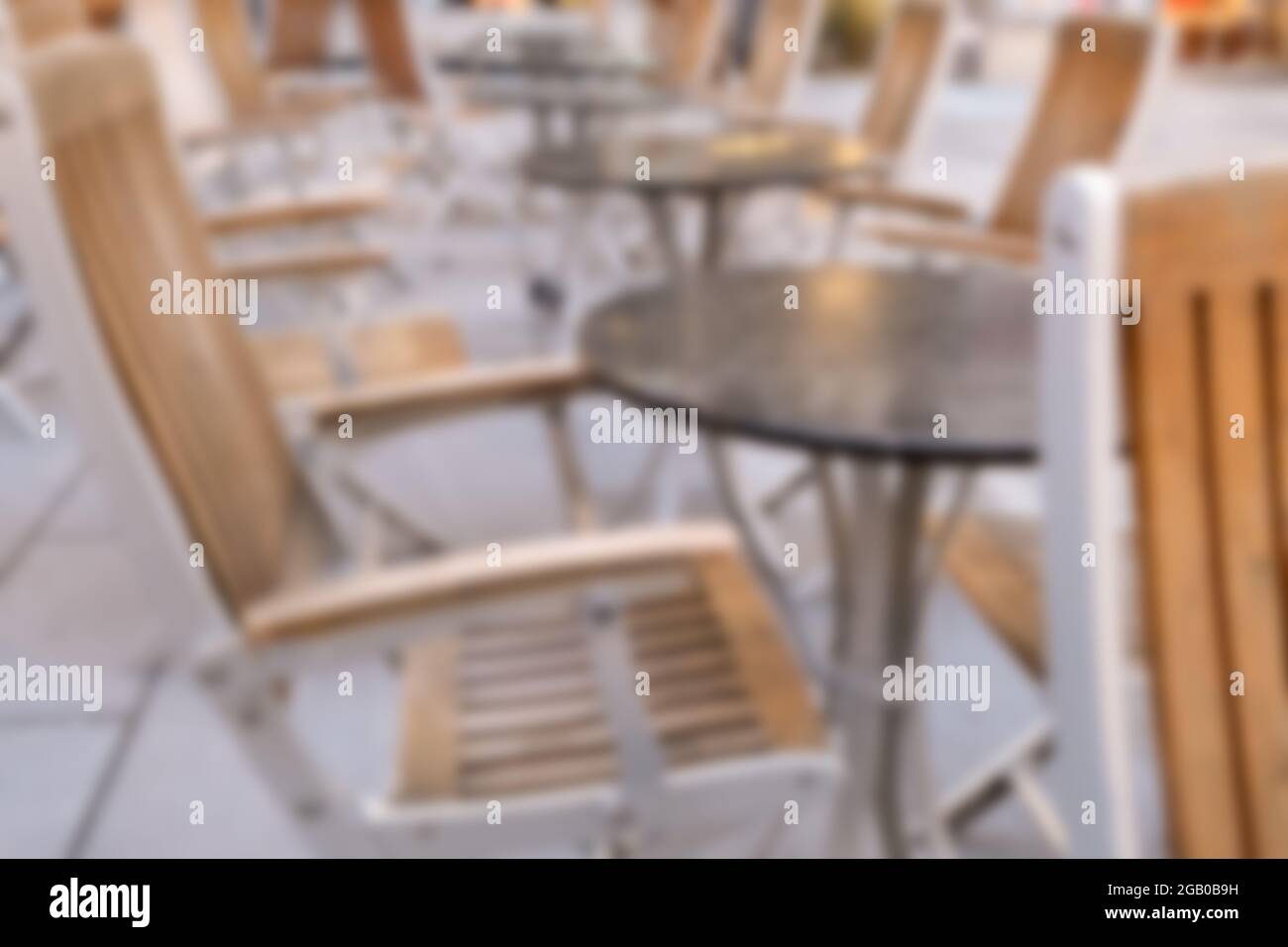 Verschwommener Hintergrund der Entspannung im Restaurant im Freien mit Holzstuhl und Tisch in der Nähe der Straße am frischen Morgen Stockfoto