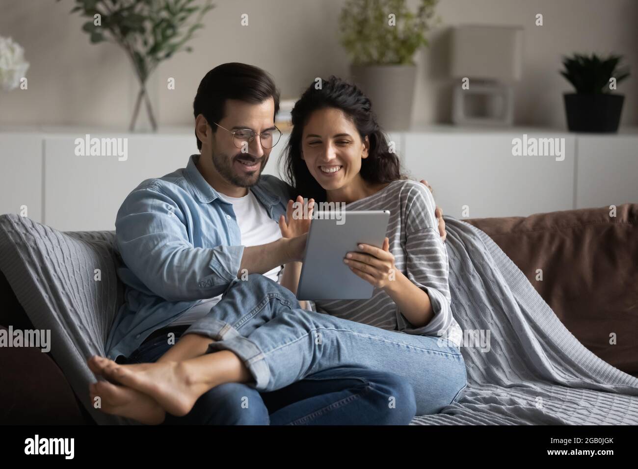 Glückliches, fröhliches Ehepaar aus den 30er Jahren, das sich zu Hause auf der Couch ausruhte Stockfoto