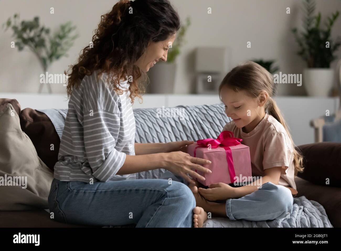 Aufgeregt Mama Geschenk an glückliche kleine Tochter Mädchen Stockfoto