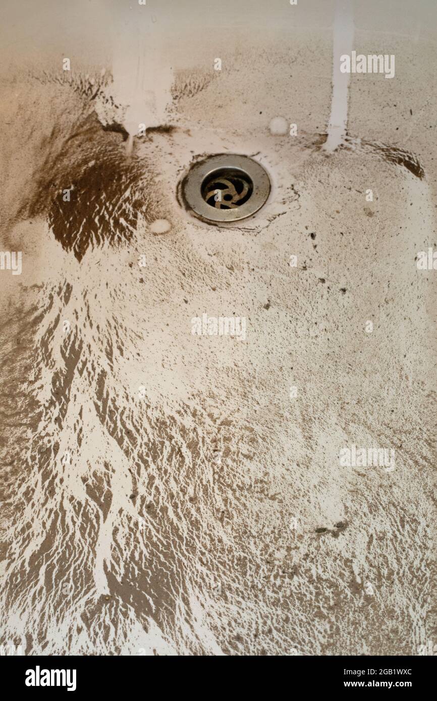 Bad, Boden, Boden mit Schmutzmuster, Detritus, Sand, Schmutz, der schmutziges Wasser hinterlässt, Tropfstellen, die aus einem Steckloch entweichen. Nach einem Rugby-Spiel. Stockfoto Bad, Boden, Boden mit Schmutzmuster, Detritus, Sand, Schmutz, der schmutziges Wasser hinterlässt, Tropfstellen, die aus einem Steckloch entweichen. Nach einem Rugby-Spiel. Stockfoto