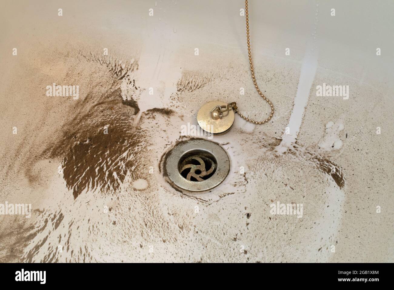 Bad, Boden, Boden mit Schmutzmuster, Detritus, Sand, Schmutz, der schmutziges Wasser hinterlässt, Tropfstellen, die aus einem Steckloch entweichen. Stockfoto Bad, Boden, Boden mit Schmutzmuster, Detritus, Sand, Schmutz, der schmutziges Wasser hinterlässt, Tropfstellen, die aus einem Steckloch entweichen. Stockfoto