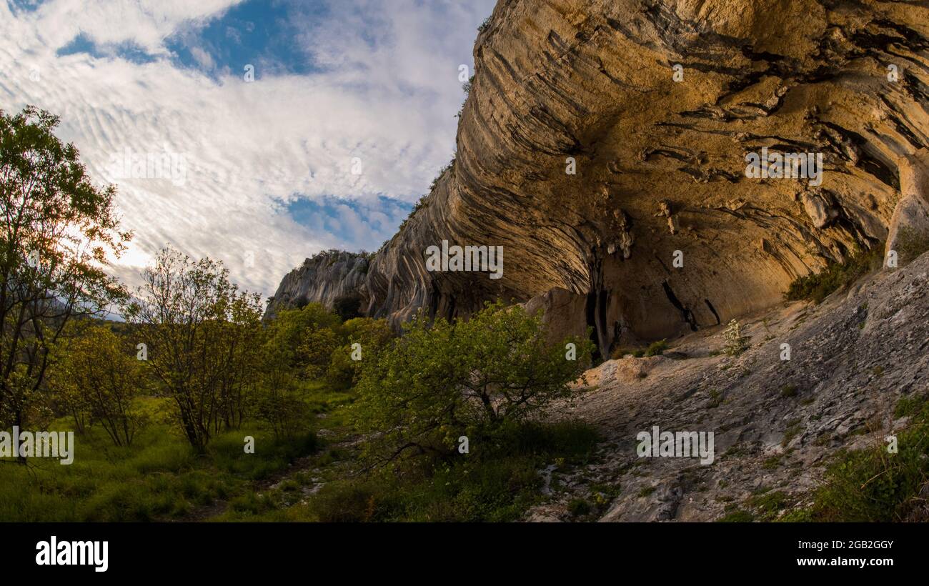 Blick auf Veli Badin, natürliche Steinklippe in den Felsen geschnitzt überlappen den Boden, an einem sonnigen Nachmittag. Majestätische Felsstruktur im slowenischen Kars Stockfoto