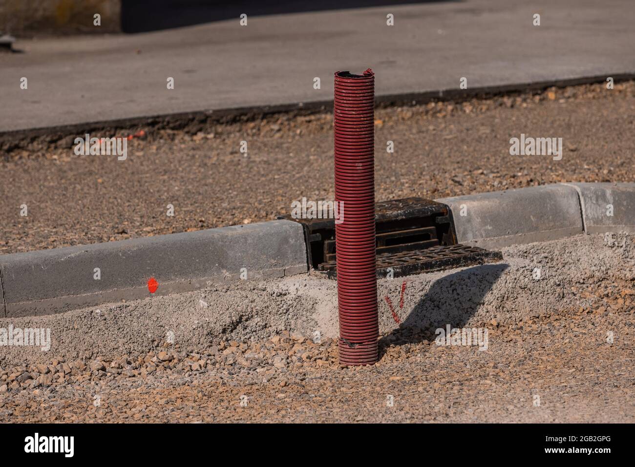 Situation auf einer Schotterstraßenreparaturbaustelle, sichtbarer Abfluss oder Elektroleitung und Abwasserabfluss. Stockfoto