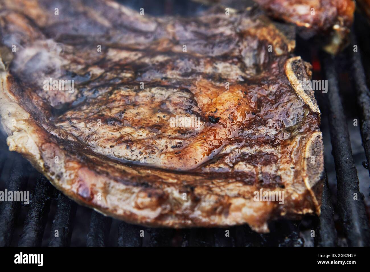 Gegrillte Rindersteaks mit Grillrauch. Grillparty Stockfoto