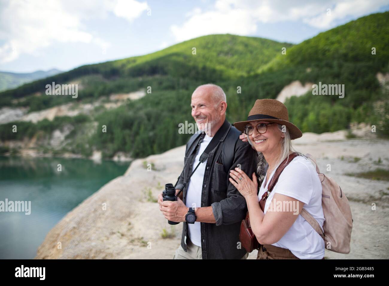 Glückliches Seniorenpaar auf Wandertour im Sommerurlaub, Blick auf die Landschaft. Stockfoto