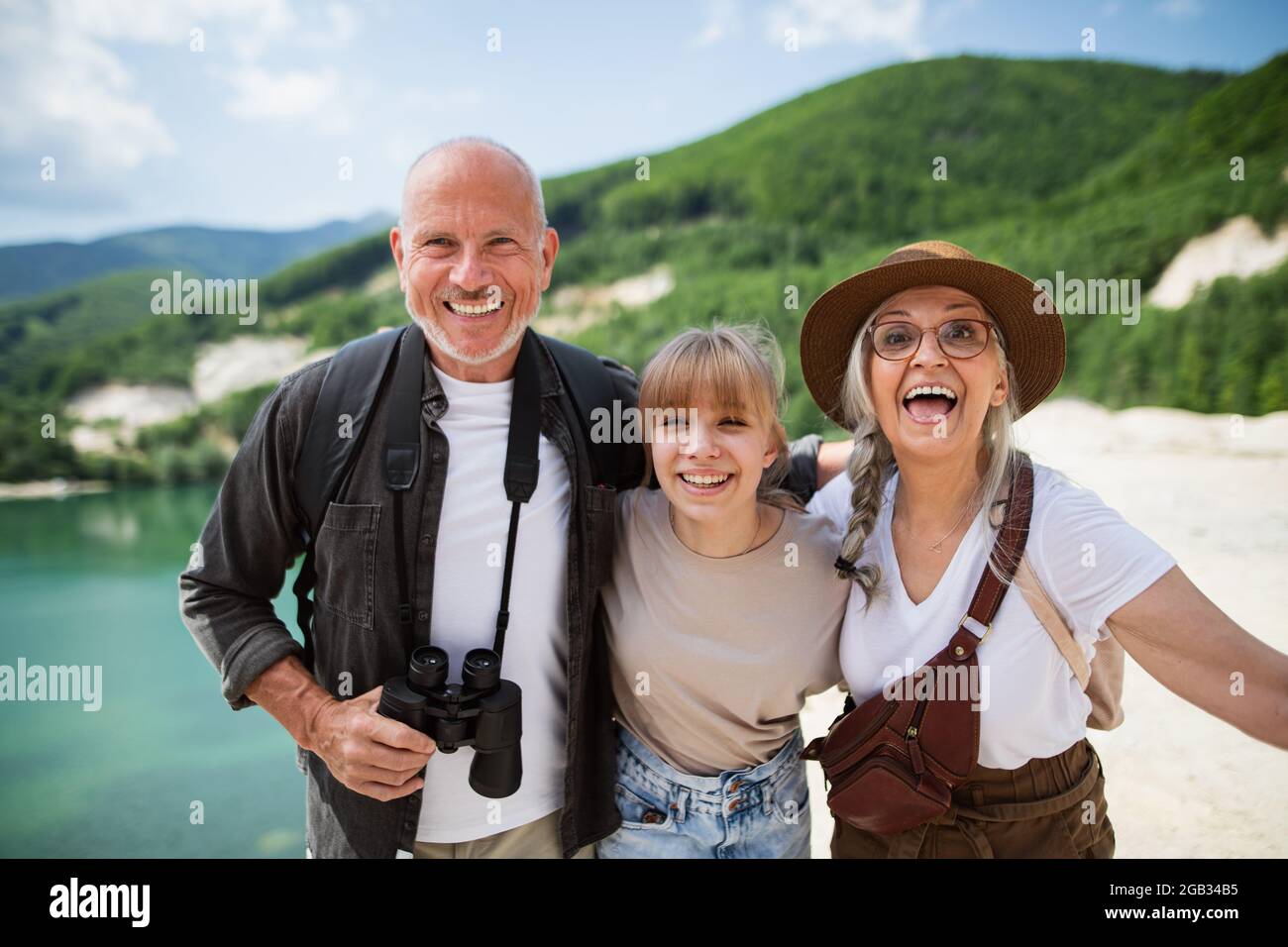 Happy preteen Mädchen mit Großeltern auf Wanderung im Sommerurlaub, Blick auf die Kamera. Stockfoto