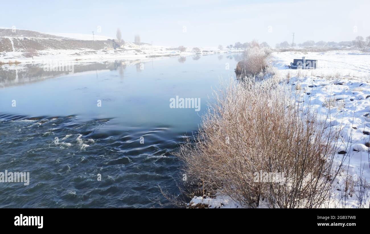 Fluss durch die winterliche Landschaft fließt. Bäume mit Frost. Stockfoto