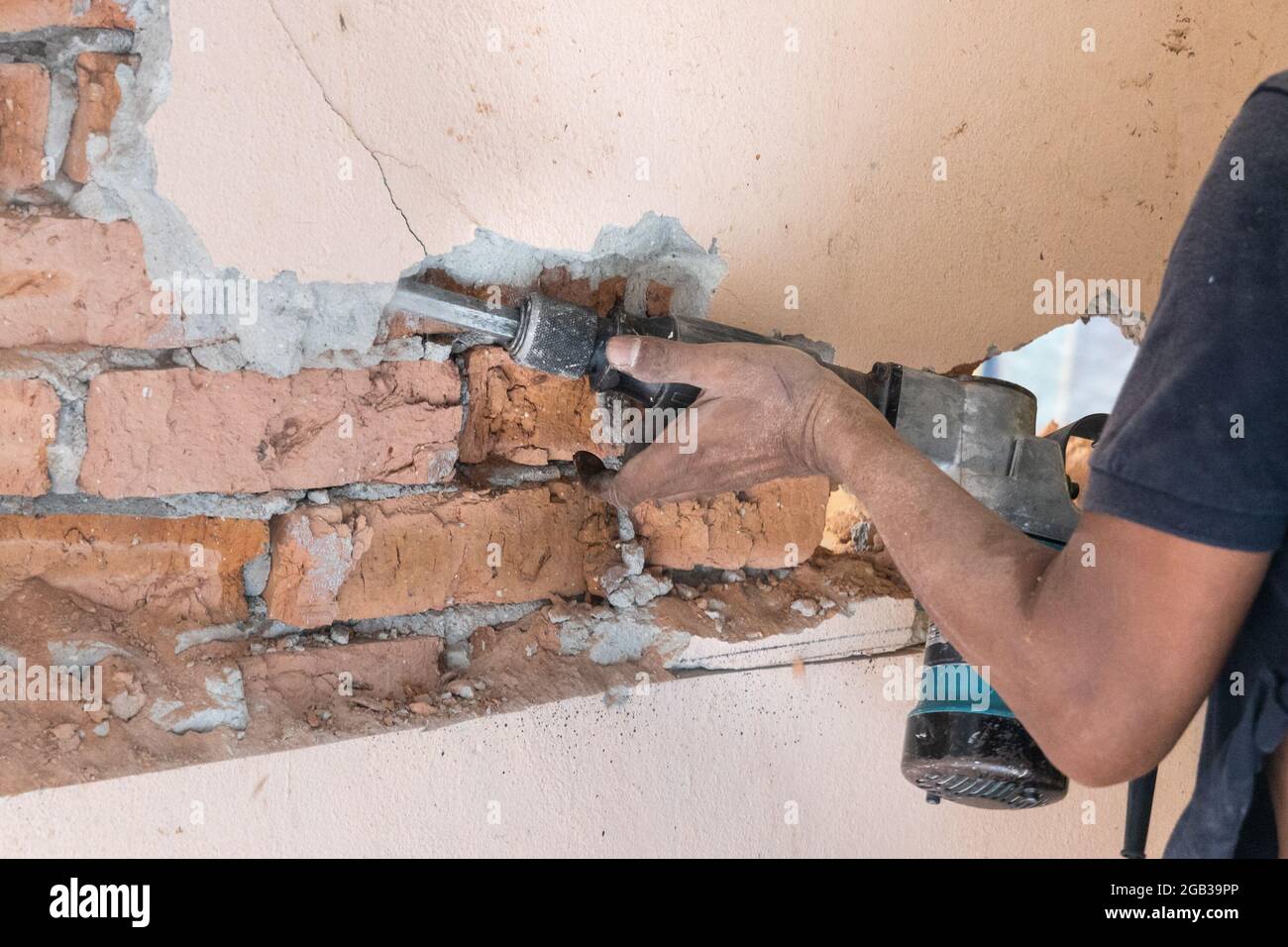 Arbeiter verwenden Abbruchhammer Bohrer, um die Wandoberfläche zu brechen. Bewegungsunschärfe beabsichtigt. Stockfoto