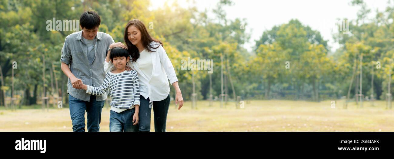 Glückliche junge Familie verbringt Zeit zusammen draußen, Thai asiatische Eltern nehmen Kind in Park oder Garten weit weg von geschäftigen Menschen zu entspannen und covid19, genießen Stockfoto