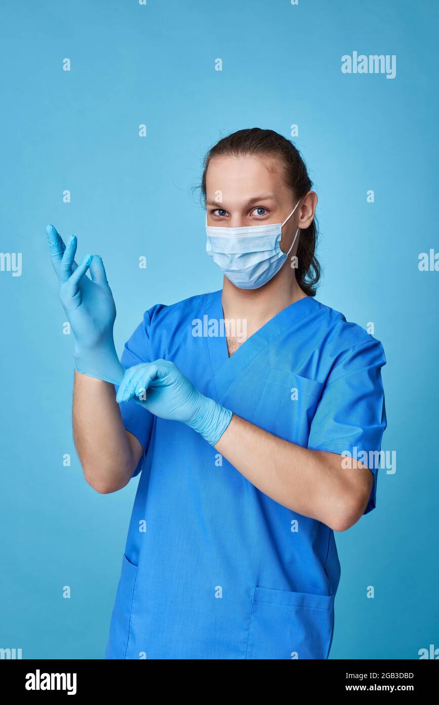 Junger Mann Arzt in Uniform trägt Handschuhe Stockfoto