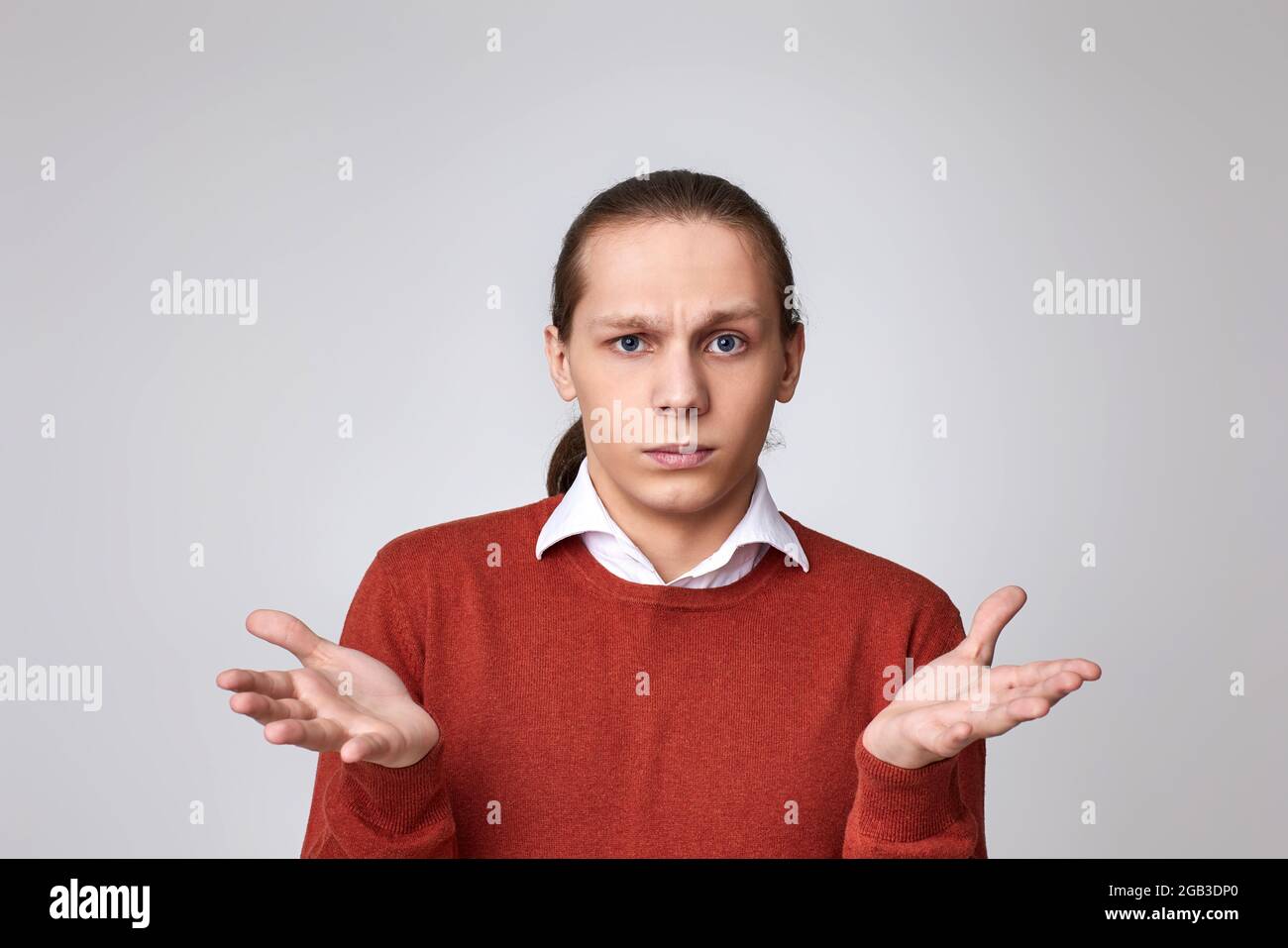 Junger, hübscher Mann mit einem Zweifel im Gesicht im Hemd Stockfoto