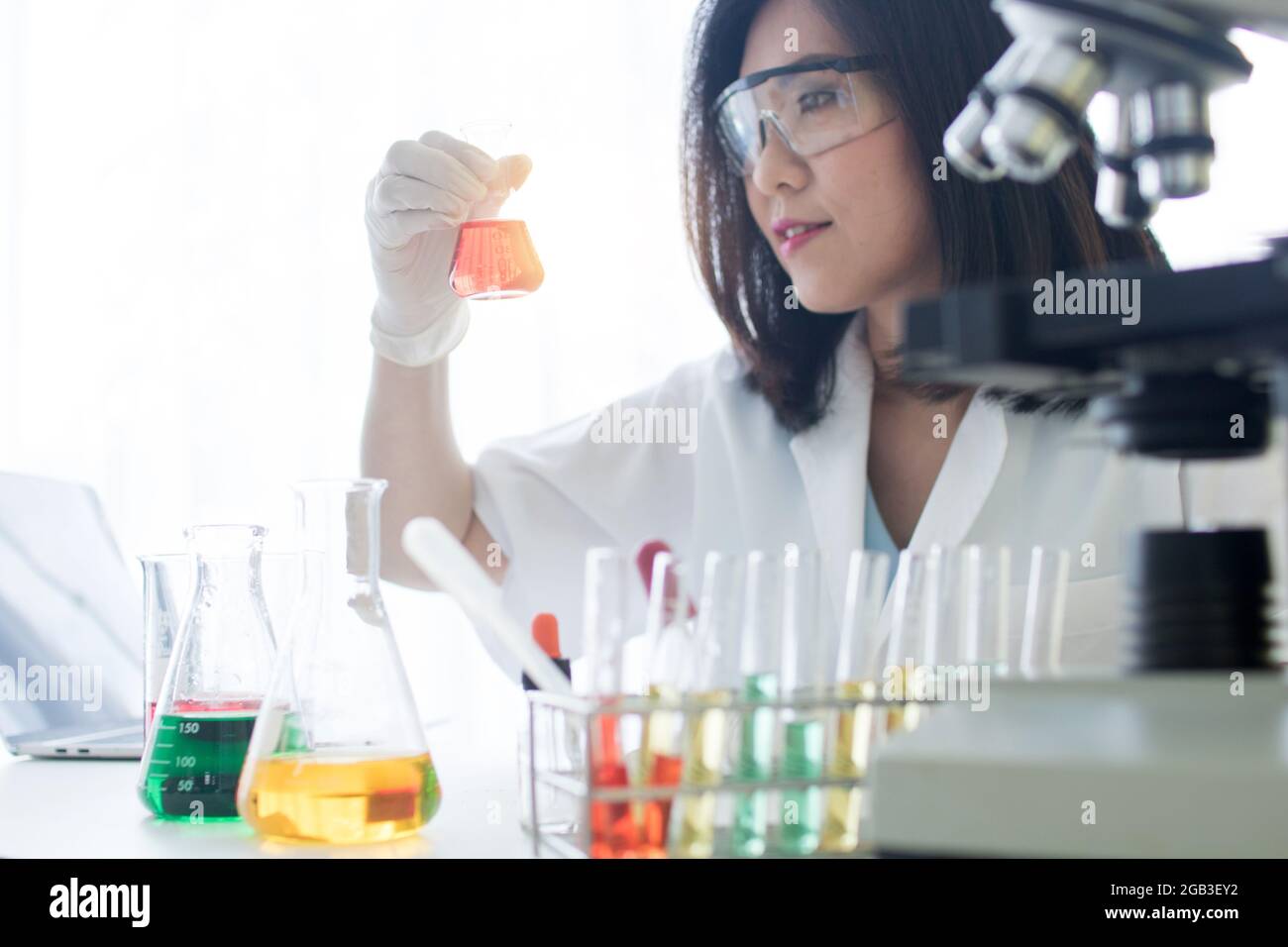 Laborwissenschaftler in einem Overall, der Forschung durchführt. Chemiker oder Arzt Forschung und Test antiretrovirale Medikamente und finden Sie Informationen auf Laptop , ho Stockfoto