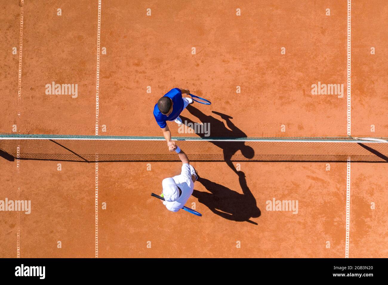 Luftaufnahme von zwei Tennisspielern, die sich gegenseitig begrüßen Das Netz nach dem Ende des Spiels Stockfoto