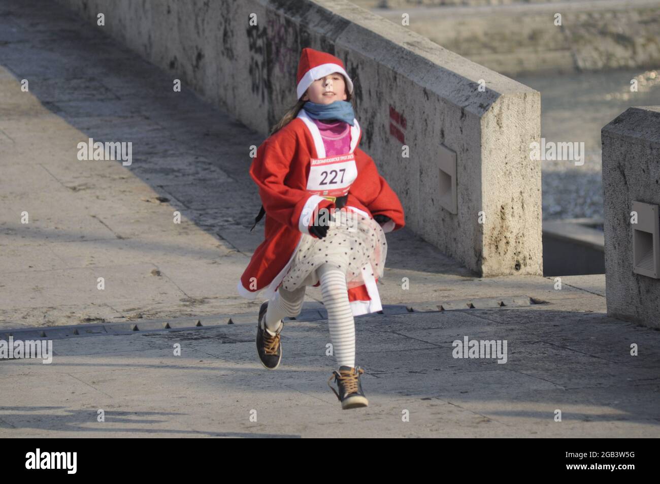 Mädchen als Weihnachtsmann gekleidet Nehmen Sie an einem traditionellen Rennen Stockfoto