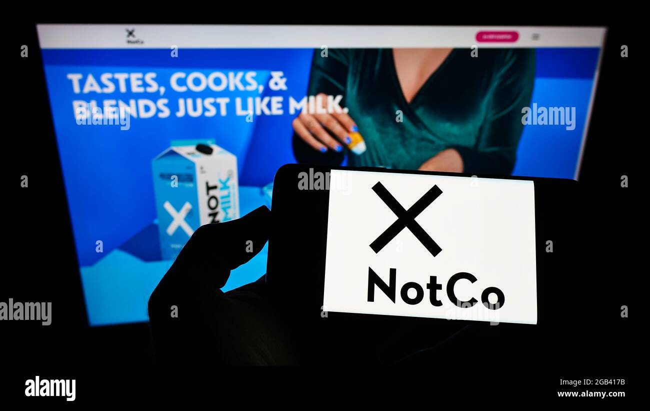 Person, die das Smartphone mit dem Logo des chilenischen Lebensmittelunternehmens The Not Company Spa (NotCo) auf dem Bildschirm vor der Website hält. Konzentrieren Sie sich auf die Telefonanzeige. Stockfoto