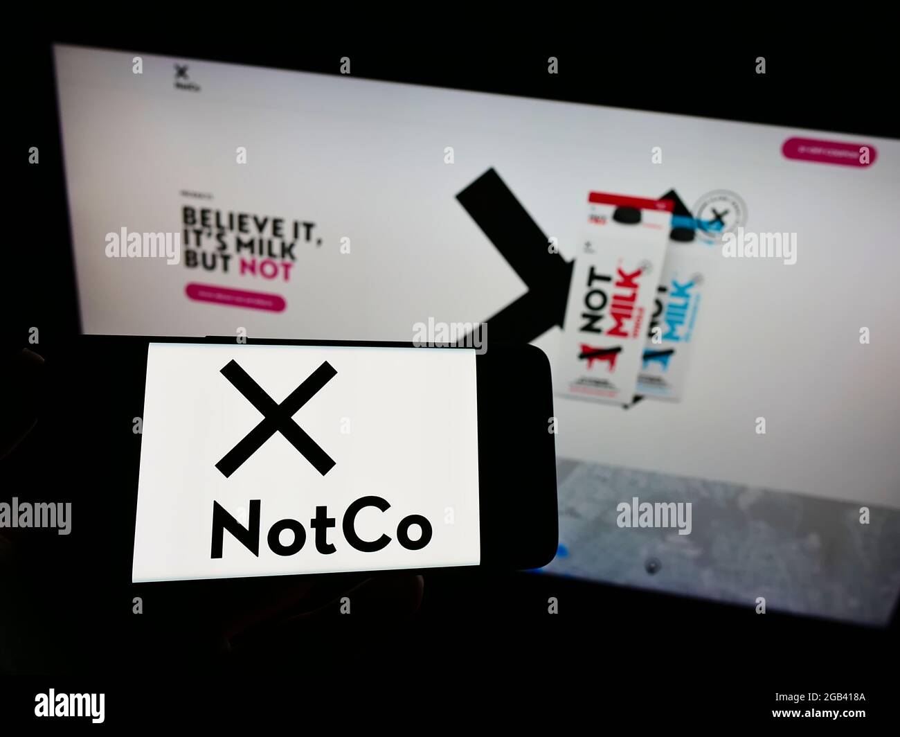 Person, die ein Mobiltelefon mit dem Logo des chilenischen Lebensmittelunternehmens The Not Company Spa (NotCo) auf dem Bildschirm vor der Webseite hält. Konzentrieren Sie sich auf die Telefonanzeige. Stockfoto