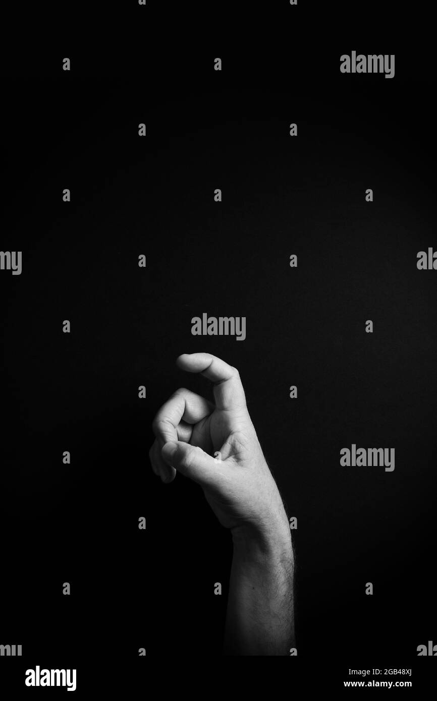 Dramatisches Schwarzweißbild der männlichen Hand, das den ASL-amerikanischen Zeichenbuchstabe X mit leerem Kopieplatz für Redakteure zeigt Stockfoto