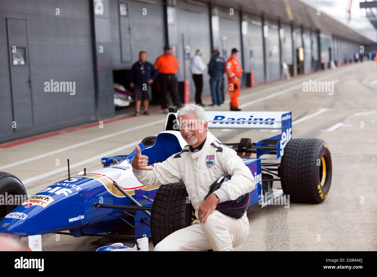 Damon Hill posiert neben seinem Weltmeister-Sieger Williams FW18 Formel-1-Auto, nachdem er mehrere Hochgeschwindigkeits-Demonstrationsrunden auf der Rennstrecke beim Silverstone Classic 2021 absolviert hatte Stockfoto
