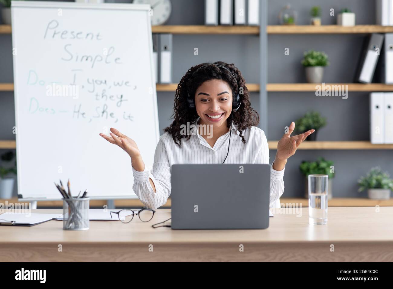 Glückliche afroamerikanische Dame auf Tafel Hintergrund, gestikulend Stockfoto