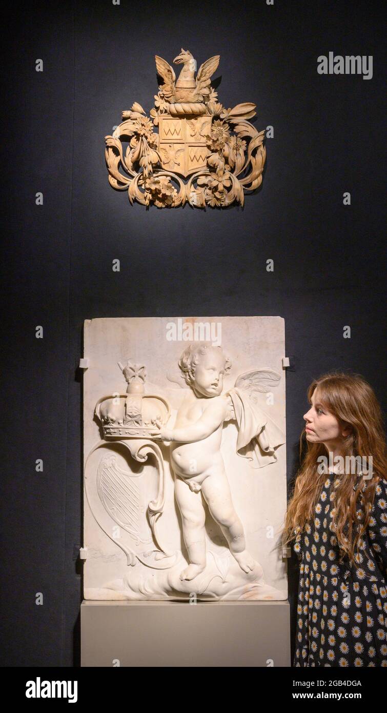 Bonhams, London, Großbritannien. 2. August 2021. Bonhams veranstaltet die Lancierung von Grinling Gibbons 300, Carving a Place in History, einem einjährigen landesweiten Festival, das den hundertsten Todestag von Großbritanniens feinstem Holzschnitzer feiert. Das Festival startet am 3. August – dem Todestag von Gibbons – mit einer nationalen Ausstellung „Centuries in the Making“ in der Bonhams New Bond Street und läuft bis zum 27. August. Bild (unten): Relief, Marmor, Putto mit Krone und Wappen Irlands, Stil von Arnold Quellin oder Grinling Gibbons, um 1686, Leihgabe des Victoria and Albert Museums Stockfoto