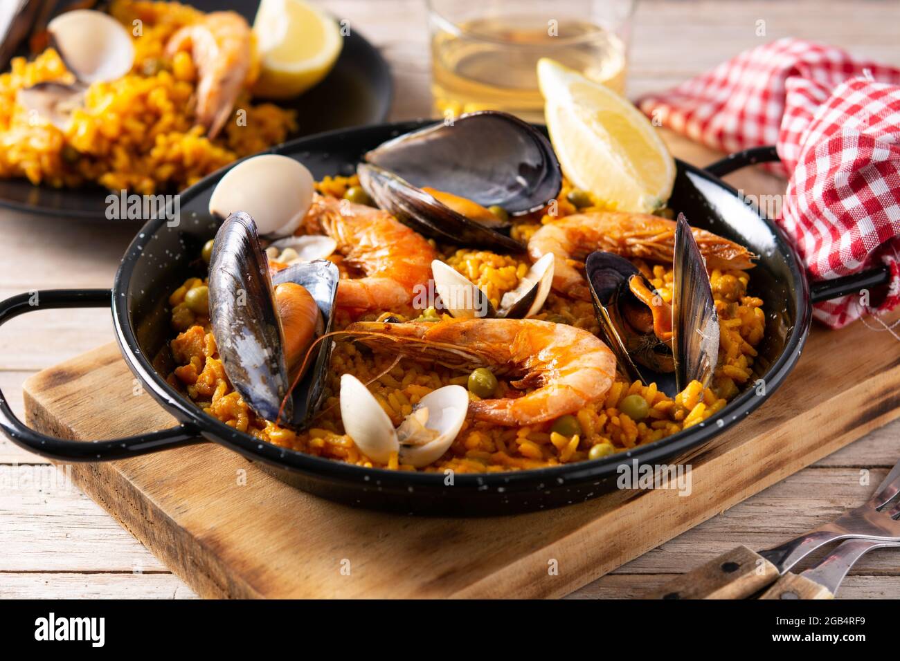 Traditionelle spanische Paella mit Meeresfrüchten auf einem Holztisch Stockfoto