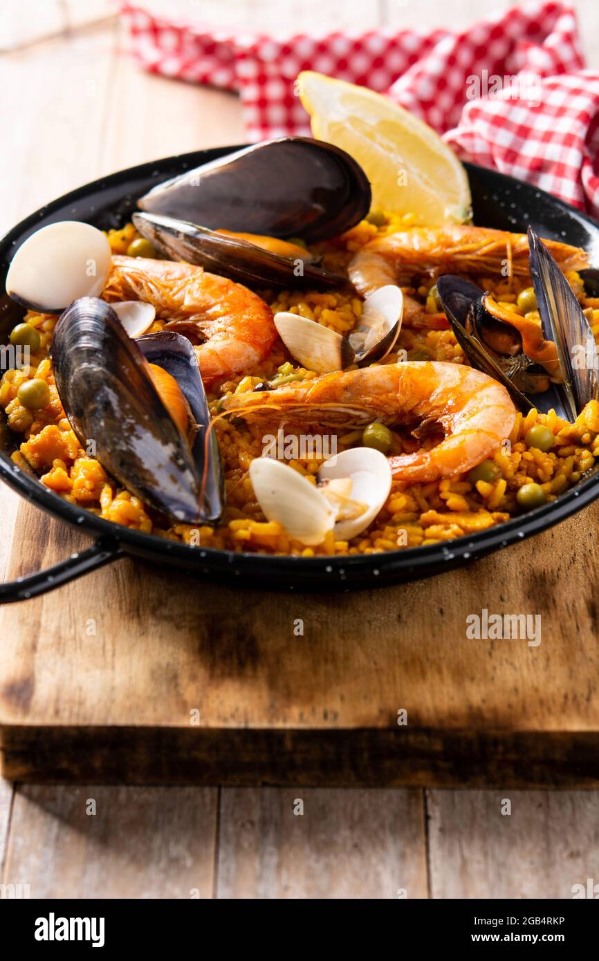 Traditionelle spanische Paella mit Meeresfrüchten auf einem Holztisch Stockfoto