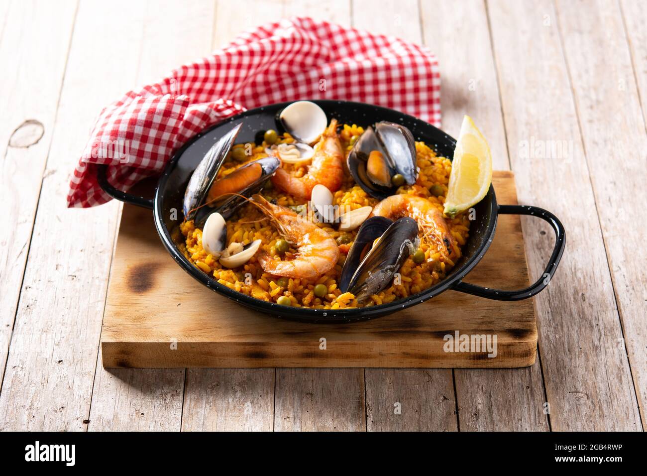 Traditionelle spanische Paella mit Meeresfrüchten auf einem Holztisch Stockfoto