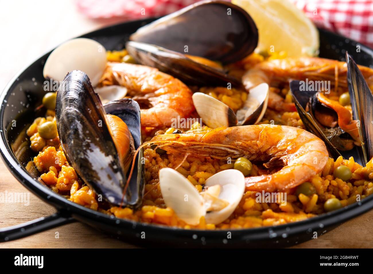 Traditionelle spanische Paella mit Meeresfrüchten auf einem Holztisch Stockfoto