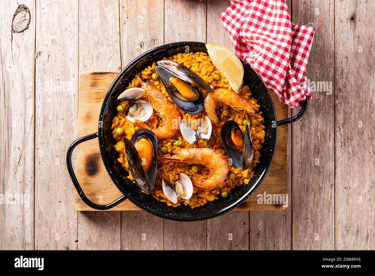 Traditionelle spanische Paella mit Meeresfrüchten auf einem Holztisch Stockfoto