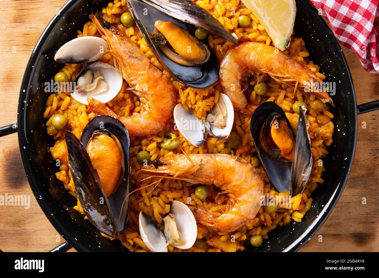 Traditionelle spanische Paella mit Meeresfrüchten auf einem Holztisch Stockfoto