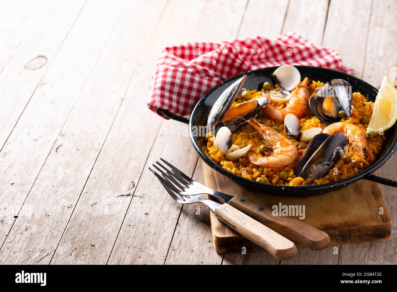 Traditionelle spanische Paella mit Meeresfrüchten auf einem Holztisch Stockfoto