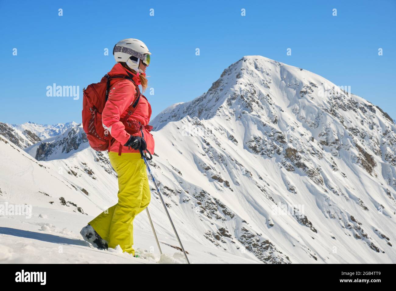 Die Skifahrerin mit Rucksack und Skistöcken blickt in die Ferne nahe dem Gipfel des Parpaner Rothorn. Atemberaubende Aussicht im Arosa Lenzerheide Resort, Schweizlan Stockfoto