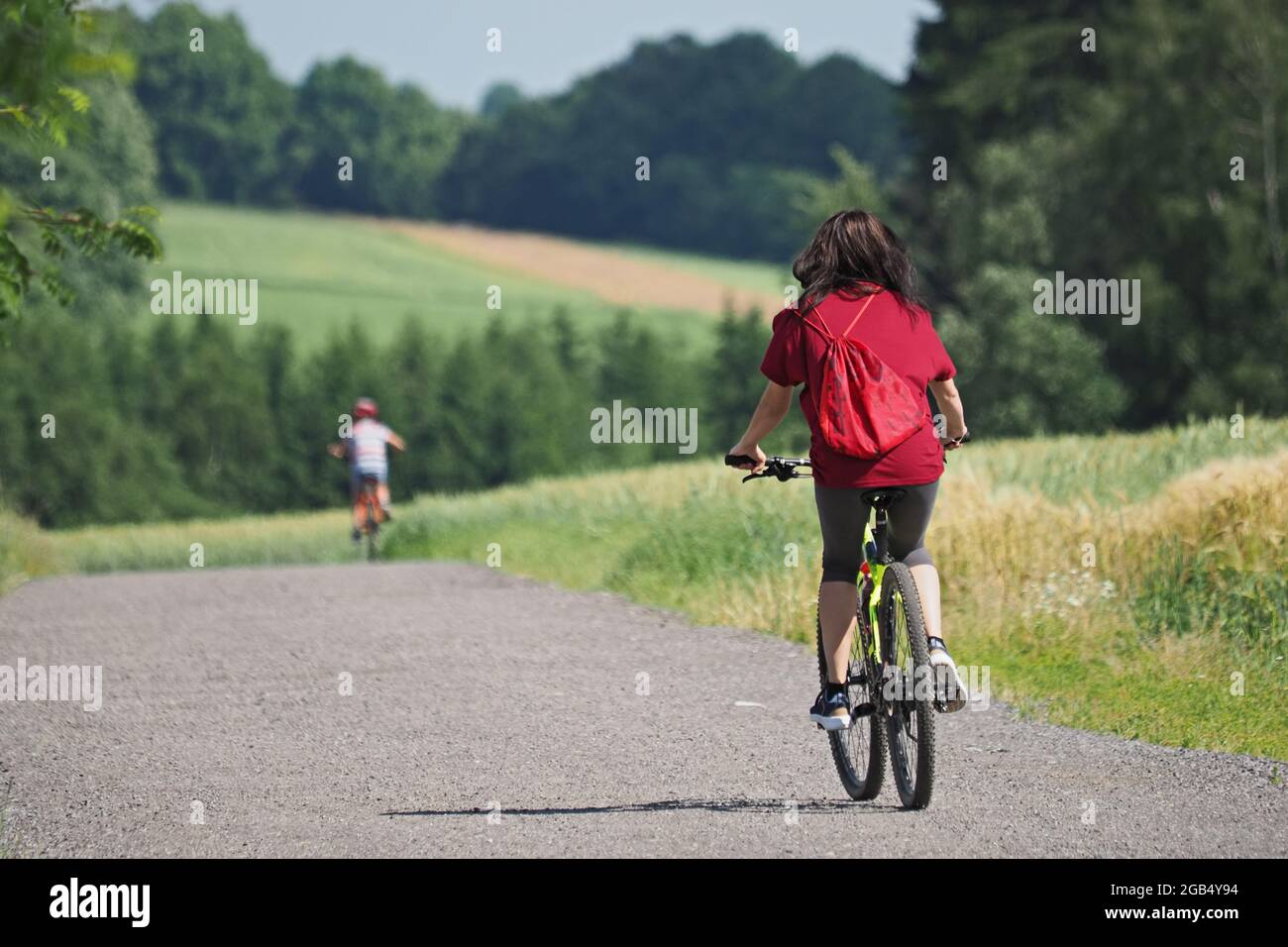 Mutter und Sohn fahren mit dem Fahrrad in die sommerliche Landschaft Stockfoto