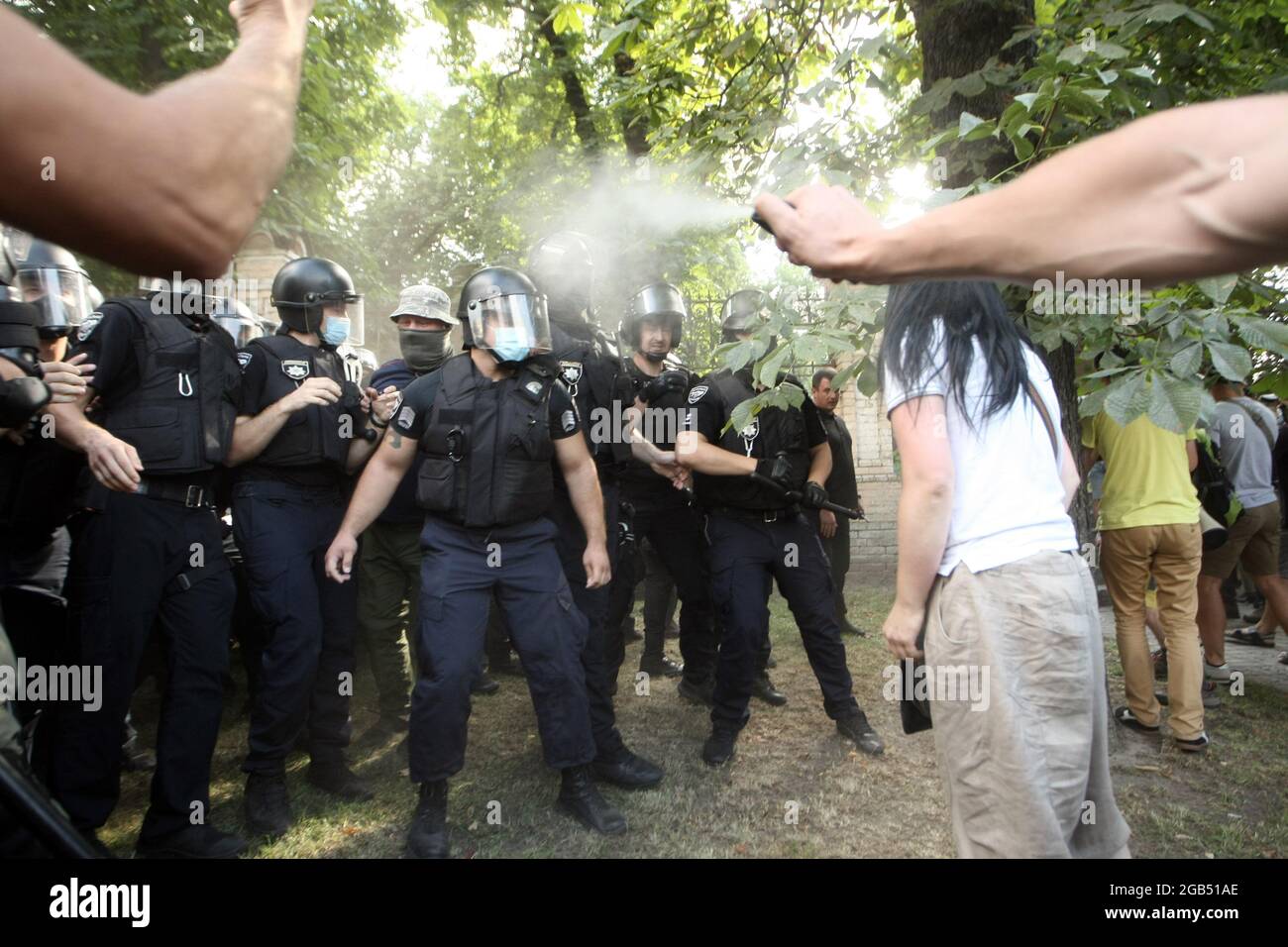 KIEW, UKRAINE - 30. JULI 2021 - EIN Mann sprüht Tränengas auf Polizeilinien, während sich Demonstranten vor dem Büro der Presseabteilung gegen das LGBT-Pride-Ereignis versammelten Stockfoto