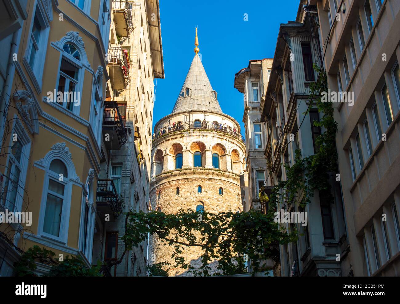 Galata Turm zwischen den alten Gebäuden gesehen. Sonnenlicht trifft auf den Galata Tower. Istanbul, Türkei Stockfoto