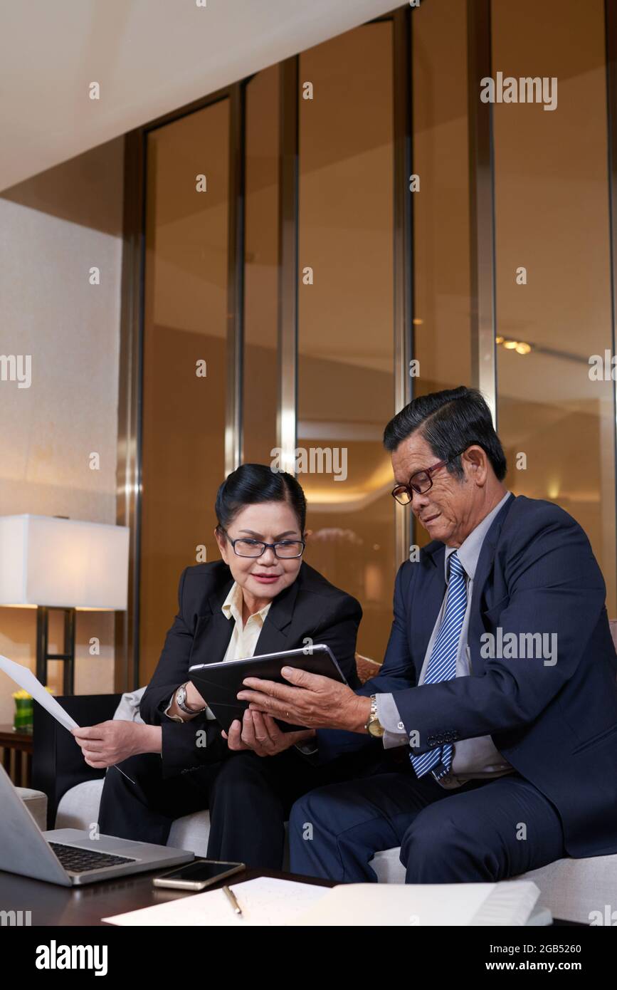 Seriöse hochrangige Kollegen aus dem Unternehmen treffen sich, um den Bericht mit wichtigen Analysedaten zu besprechen Stockfoto