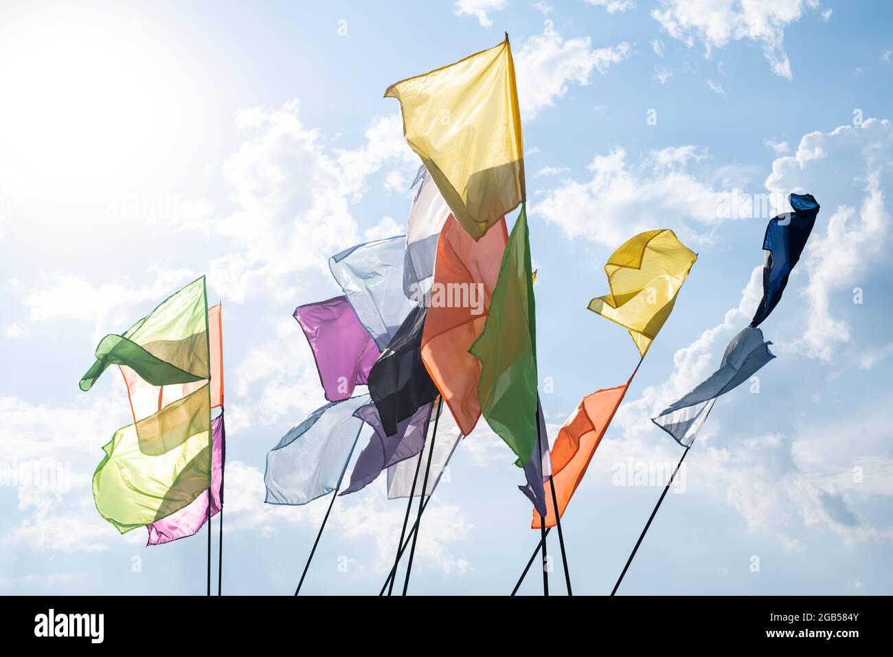 Bunte Fahnen flattern auf dem blauen Himmel Hintergrund. Festivalfeier und Party-Karneval-Konzept Stockfoto