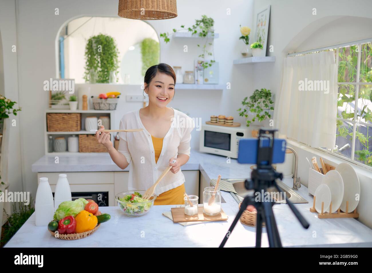 Food-Blogger, der Videos mit einer Telefonkamera in der heimischen Küche aufzeichnet Stockfoto