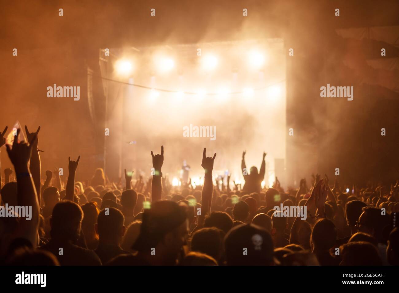Silhouetten von Konzertbesuchern vor hellen Bühnenlichtern. Rock- und Metal-Musikkonzept Stockfoto