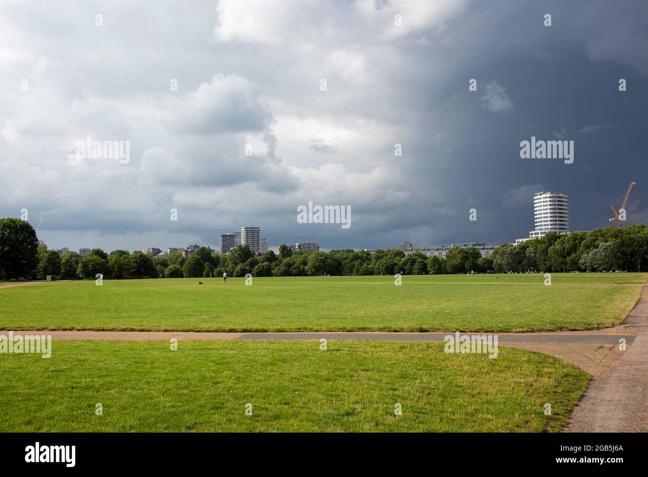 Der Turm des Marble Arch Place, der über den Hyde Park hinweg gesehen wird und in der Ferne ein Sturm aufbraut. London, Großbritannien, Stockfoto