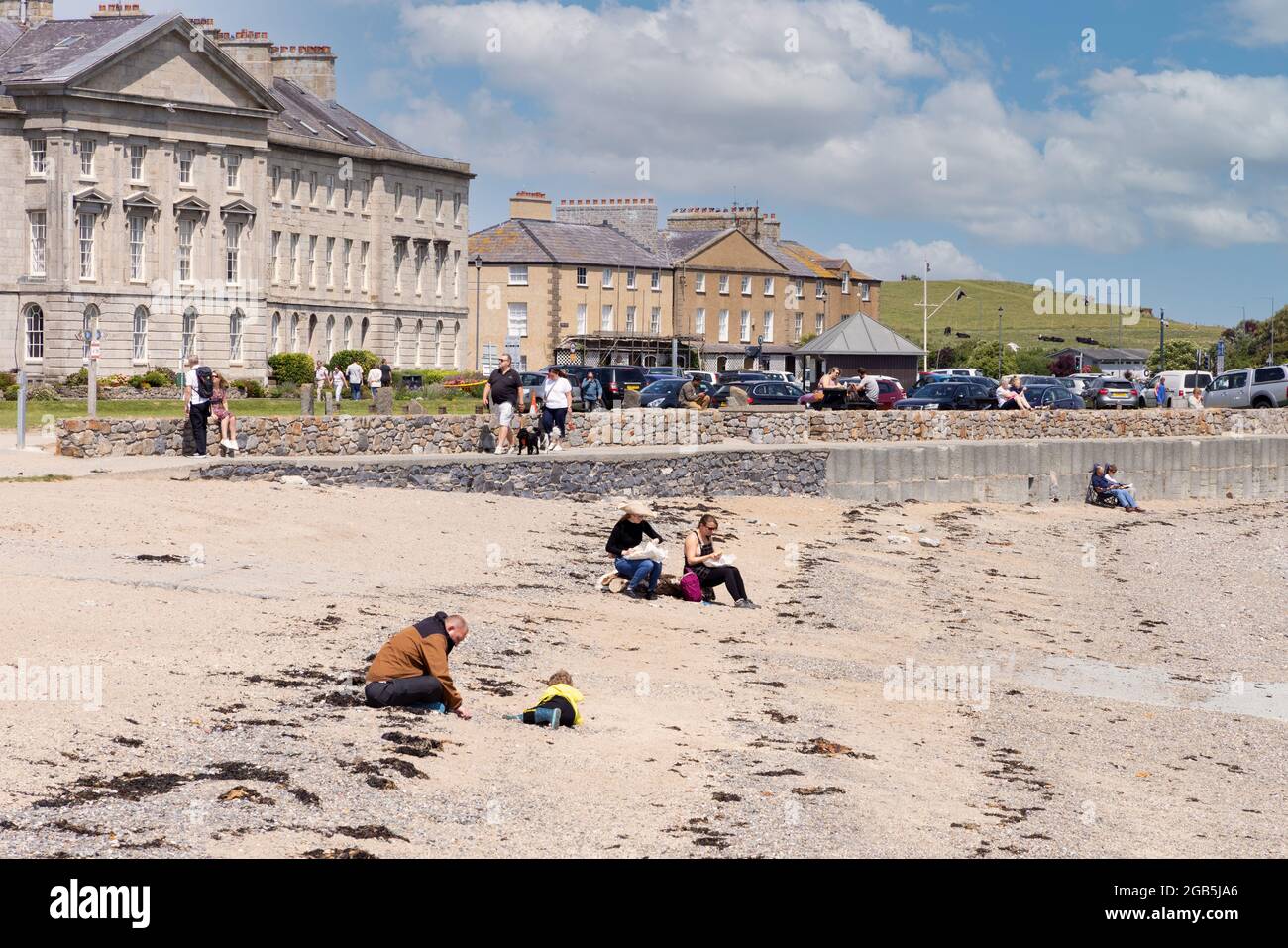 Urlaub in Großbritannien im Sommer; Menschen am Strand, Beaumaris Beach, Beaumaris Seafront, Anglesey Wales Großbritannien Stockfoto