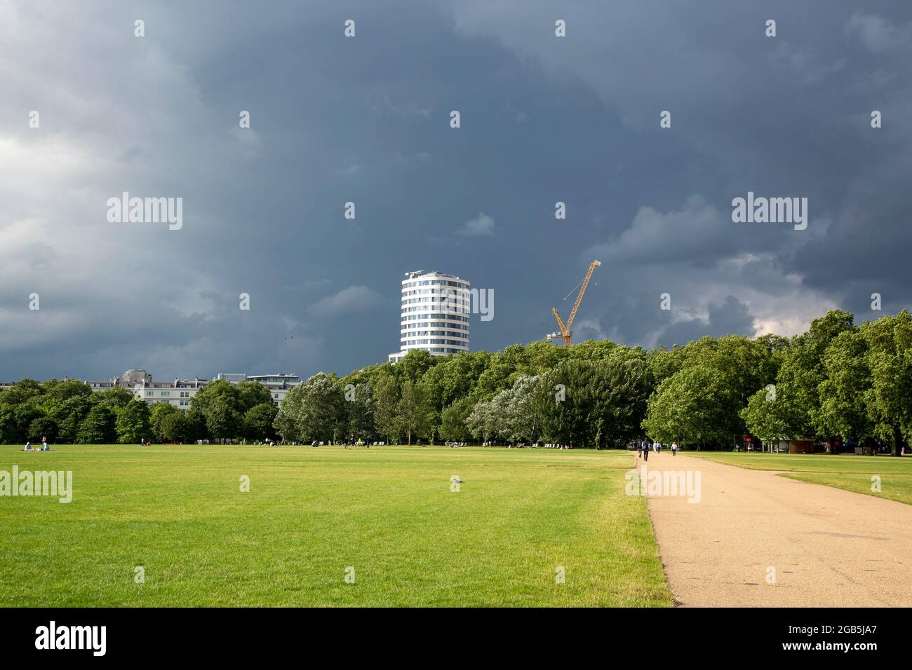 Der Turm des Marble Arch Place, der über den Hyde Park hinweg gesehen wird und in der Ferne ein Sturm aufbraut. London, Großbritannien, Stockfoto