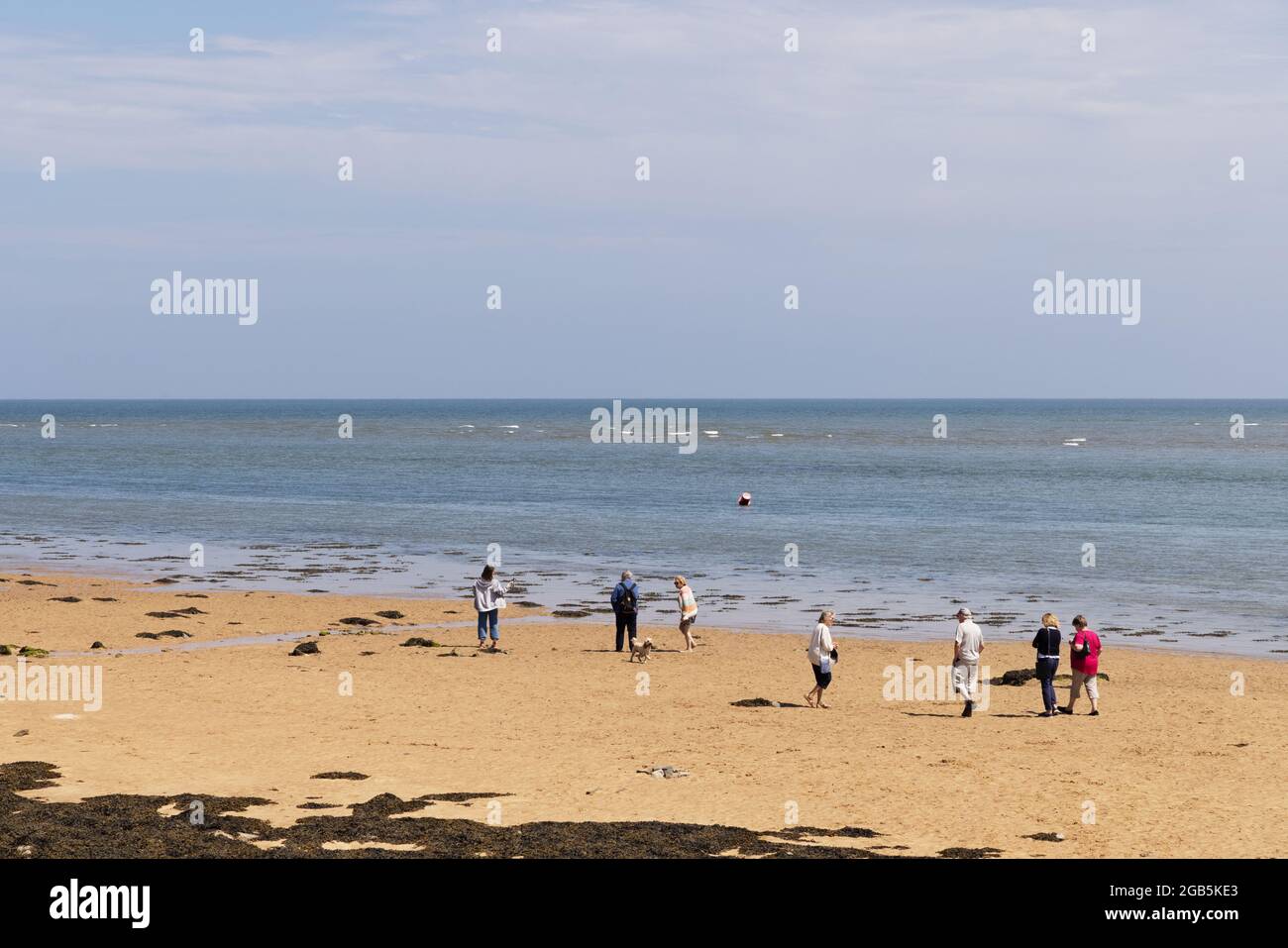 Walisischer Strand - Leute am Strand an einem sonnigen Tag im Sommer - im Juli auf Aufenthalt; Red Wharf Bay, Anglesey, Wales Großbritannien Stockfoto