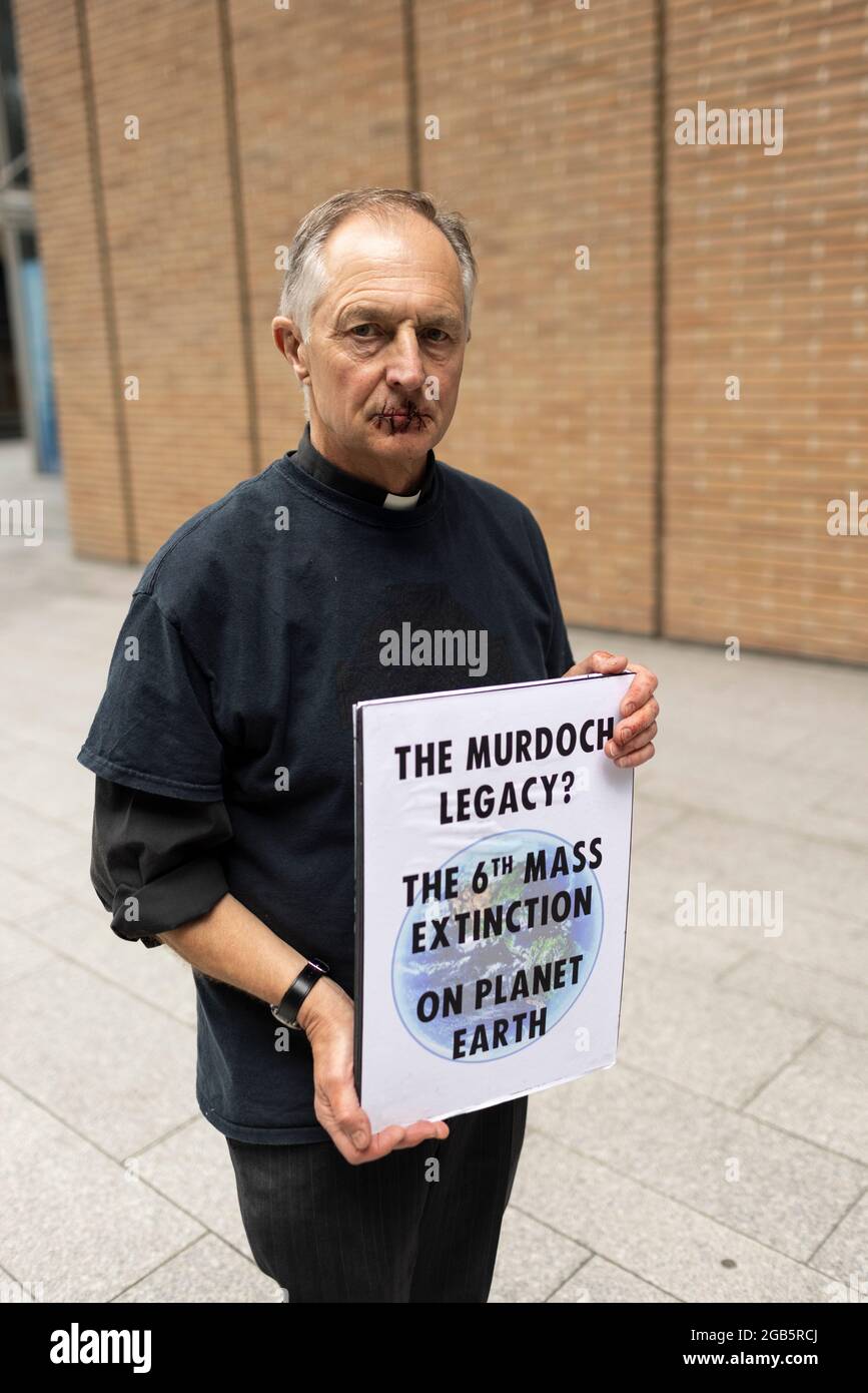 London, Großbritannien. 2. August 2021: Reverend Tim Hewes, 71 Jahre alt, Nähte heute mittags seine Lippen vor den Büros von News UK zu. Seine Aktion bestand darin, die Aufmerksamkeit auf die Stillegungen der Klimawissenschaft durch Rupert Murdoch und News Corp zu lenken, was zu einem katastrophalen Mangel an wirksamen Maßnahmen zur Bewältigung der Klimakrise geführt hat. Er hielt Plakate mit den Worten: „Murdoch hat das getan, gedämpfte Klimawissenschaft“, „Murdoch zum Ökozid auf die Anklagebank“, „das Murdoch-Erbe? Das 6. Massenaussterben auf dem Planeten Erde“. London, Großbritannien. Kredit: Joshua Windsor/Alamy Live Nachrichten Stockfoto