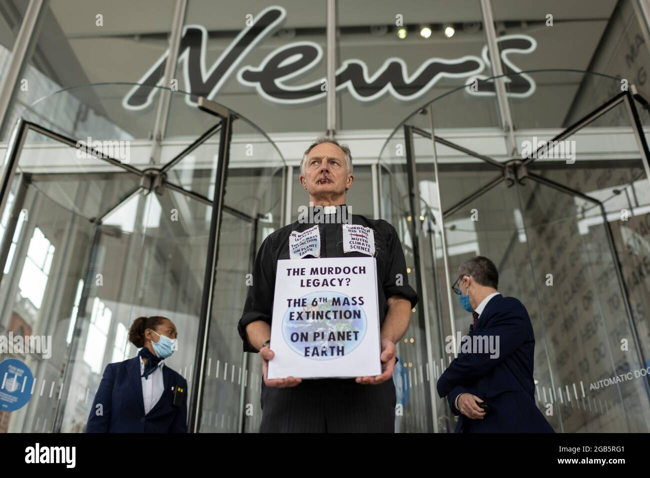 London, Großbritannien. 2. August 2021: Reverend Tim Hewes, 71 Jahre alt, Nähte heute mittags seine Lippen vor den Büros von News UK zu. Seine Aktion bestand darin, die Aufmerksamkeit auf die Stillegungen der Klimawissenschaft durch Rupert Murdoch und News Corp zu lenken, was zu einem katastrophalen Mangel an wirksamen Maßnahmen zur Bewältigung der Klimakrise geführt hat. Er hielt Plakate mit den Worten: „Murdoch hat das getan, gedämpfte Klimawissenschaft“, „Murdoch zum Ökozid auf die Anklagebank“, „das Murdoch-Erbe? Das 6. Massenaussterben auf dem Planeten Erde“. London, Großbritannien. Kredit: Joshua Windsor/Alamy Live Nachrichten Stockfoto