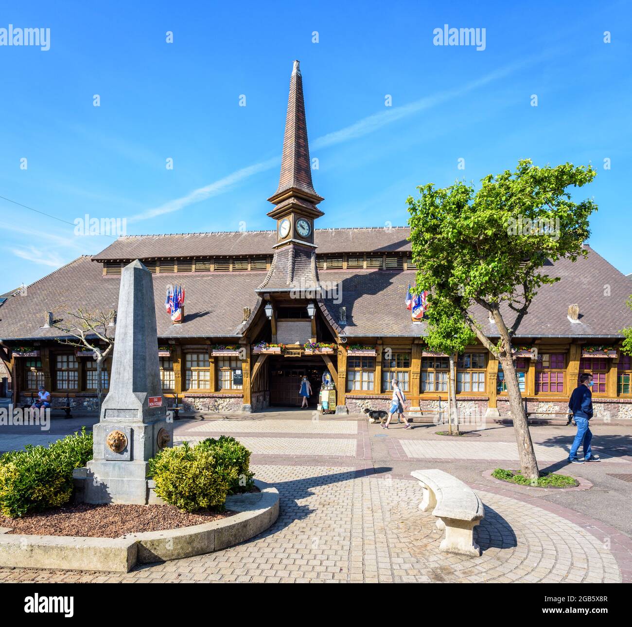 Der Marechal Foch-Platz in Etretat, Frankreich, mit dem Alten Markt, einer überdachten Markthalle aus dem Jahr 1927, und einem Obelisk-förmigen Brunnen an einem sonnigen Morgen. Stockfoto