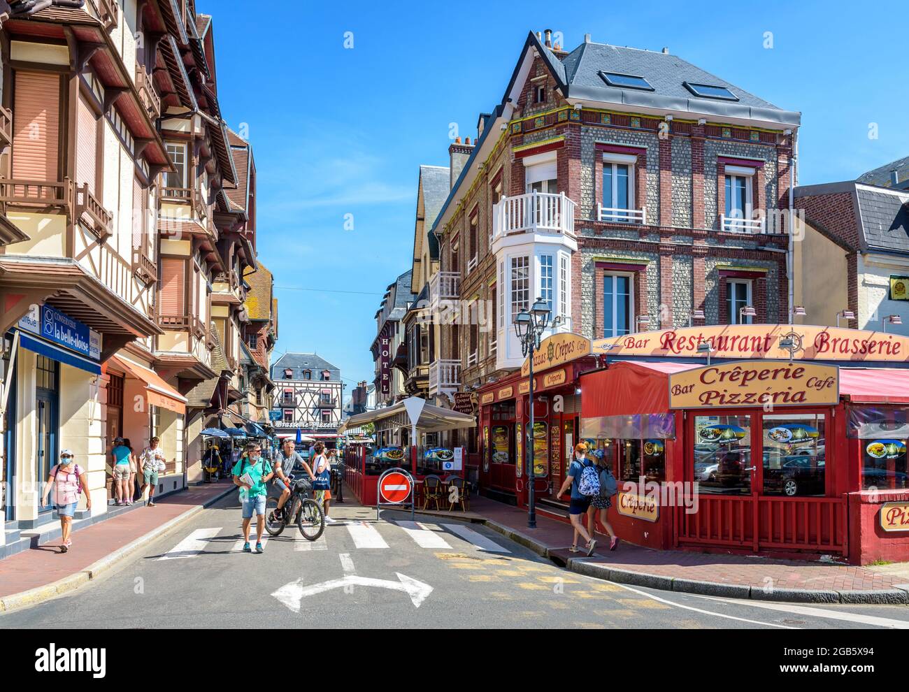Touristen bummeln auf dem Boulevard des Präsidenten Rene Coty in Etretat, Frankreich, gesäumt von Restaurants, Souvenirläden, Hotels und typischen Gebäuden. Stockfoto